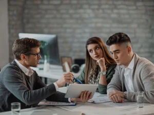 young-couple-using-digital-tablet-with-their-insurance-agent-consultations-office